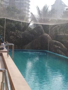 Transparent bird net installed above hotel swimming pool