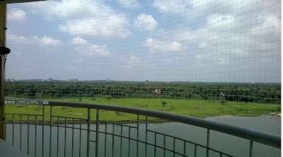 Transparent bird protection net installed on scenic river-facing balcony without blocking the view